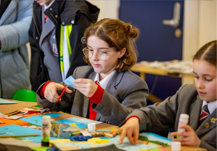 Schoolchildren in uniform taking part in a craft activity at a table