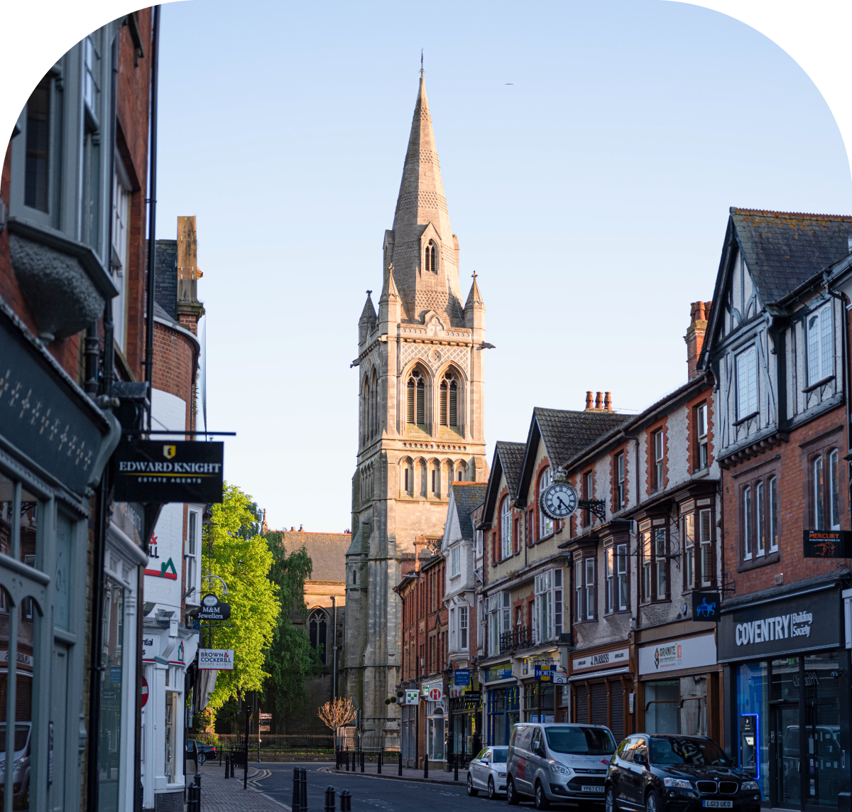Street of terraced shops beneath the tower and spire of St Andrew's Church