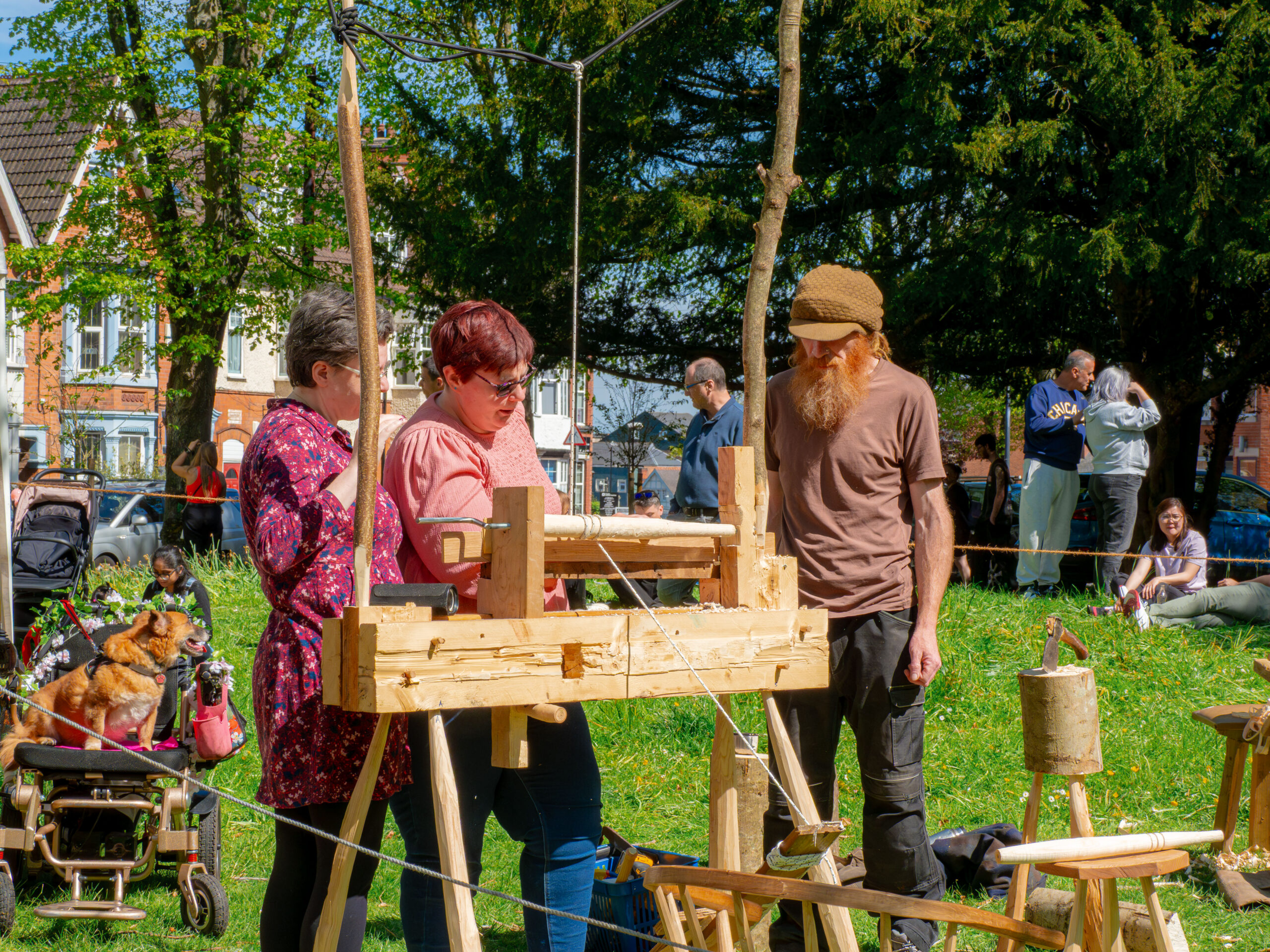 Craftsperson demonstrating traditional woodturning to onlookers at an outdoor festival