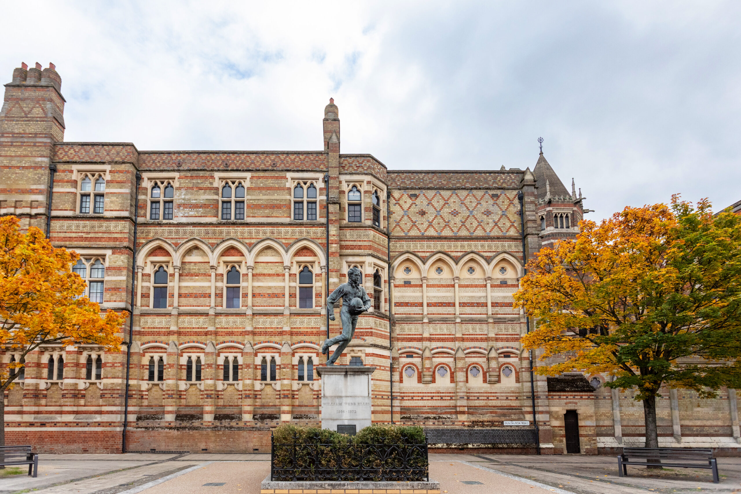 Ornate Victorian Gothic buildings of Rugby School framed by autumn trees