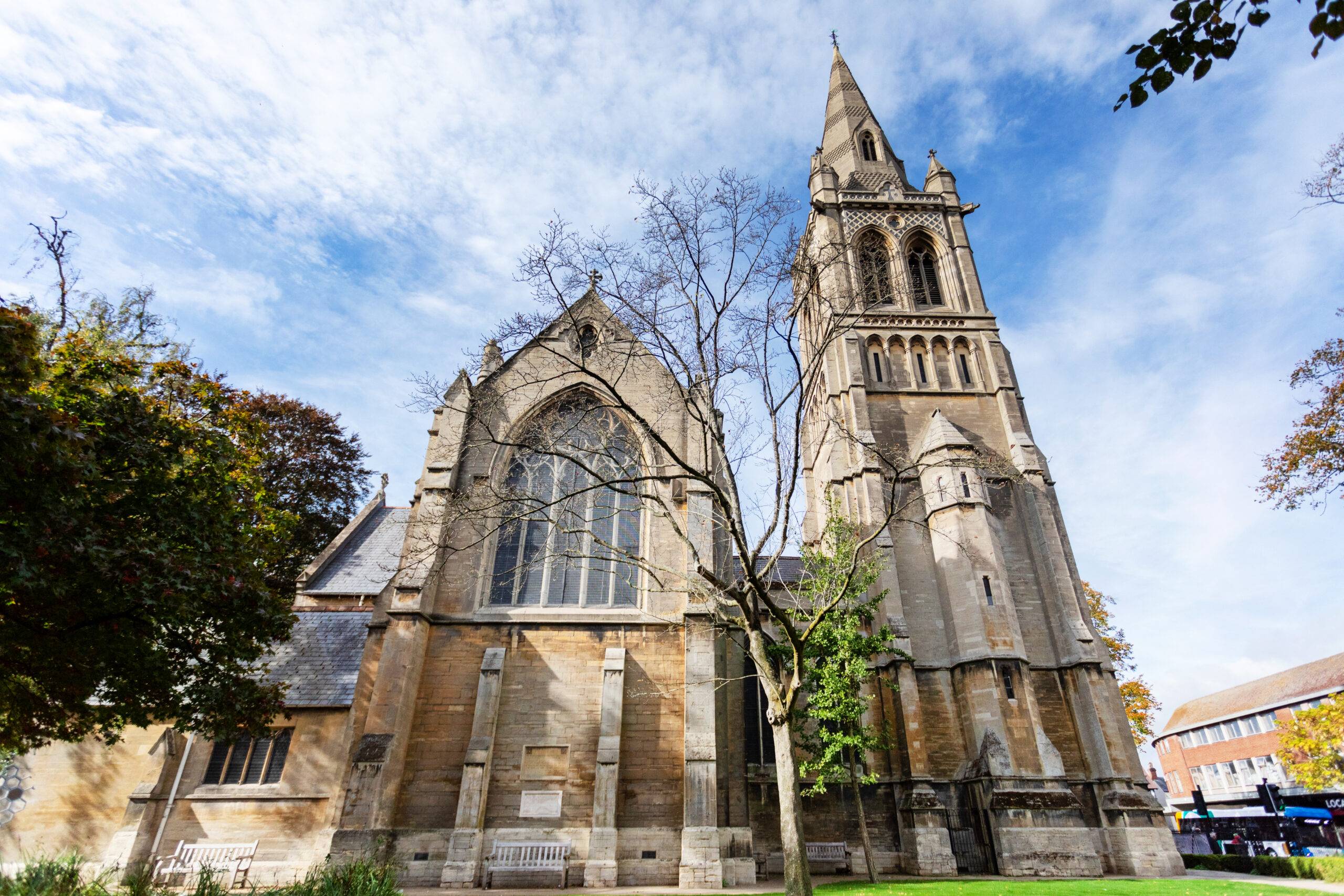 Stone exterior and tall tower of St Andrew's Church against a blue sky