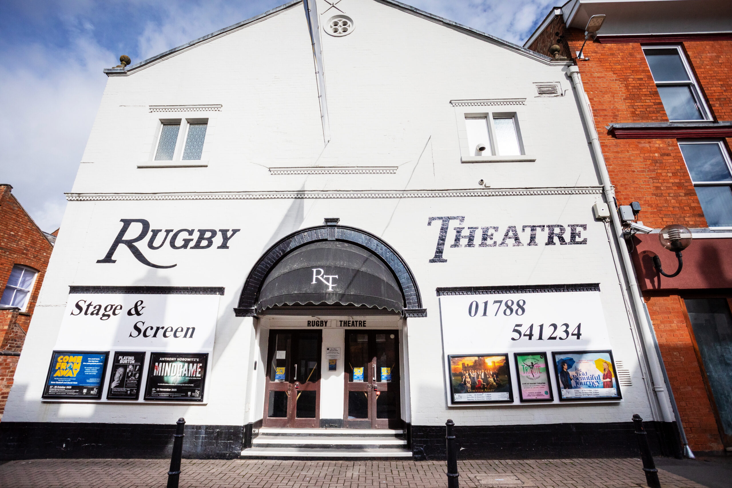 Frontage of the Rugby Theatre, a white building with Rugby Theatre signage