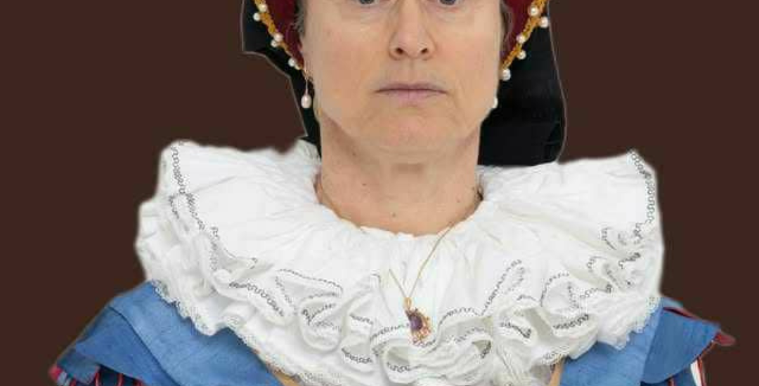 Lady in tudor outfit with a ruff and head dress.