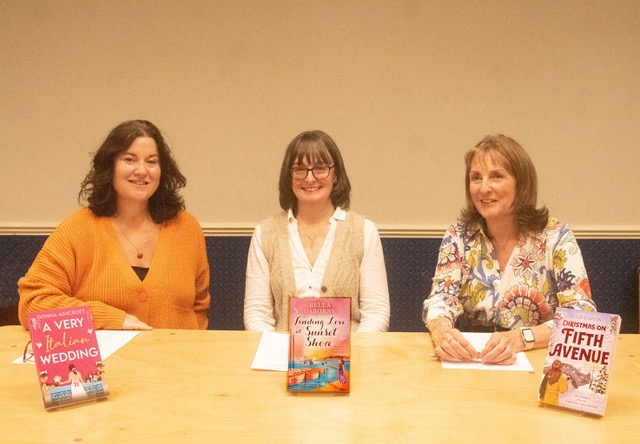 Three women sat behind a table.