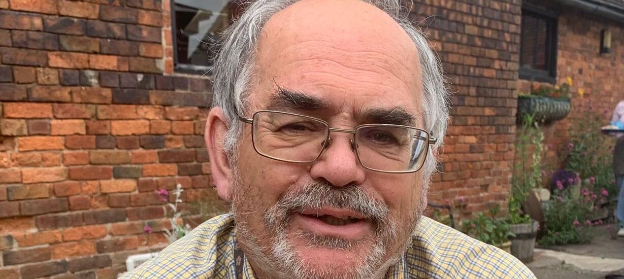 Picture of a man with a brick wall in the background