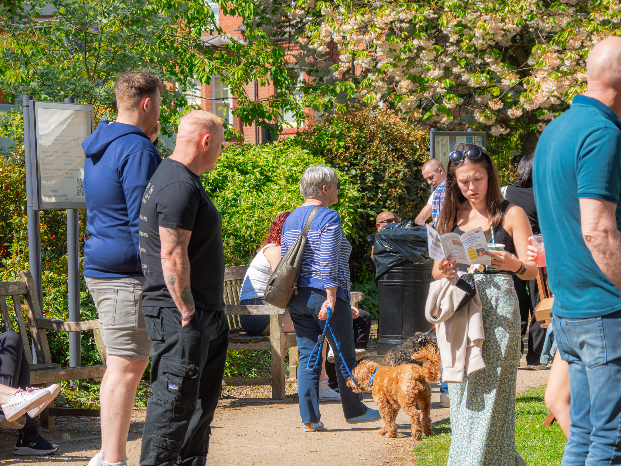 Crowd of people dwelling in an outdoor space at an event, looking at attractions or leaflets
