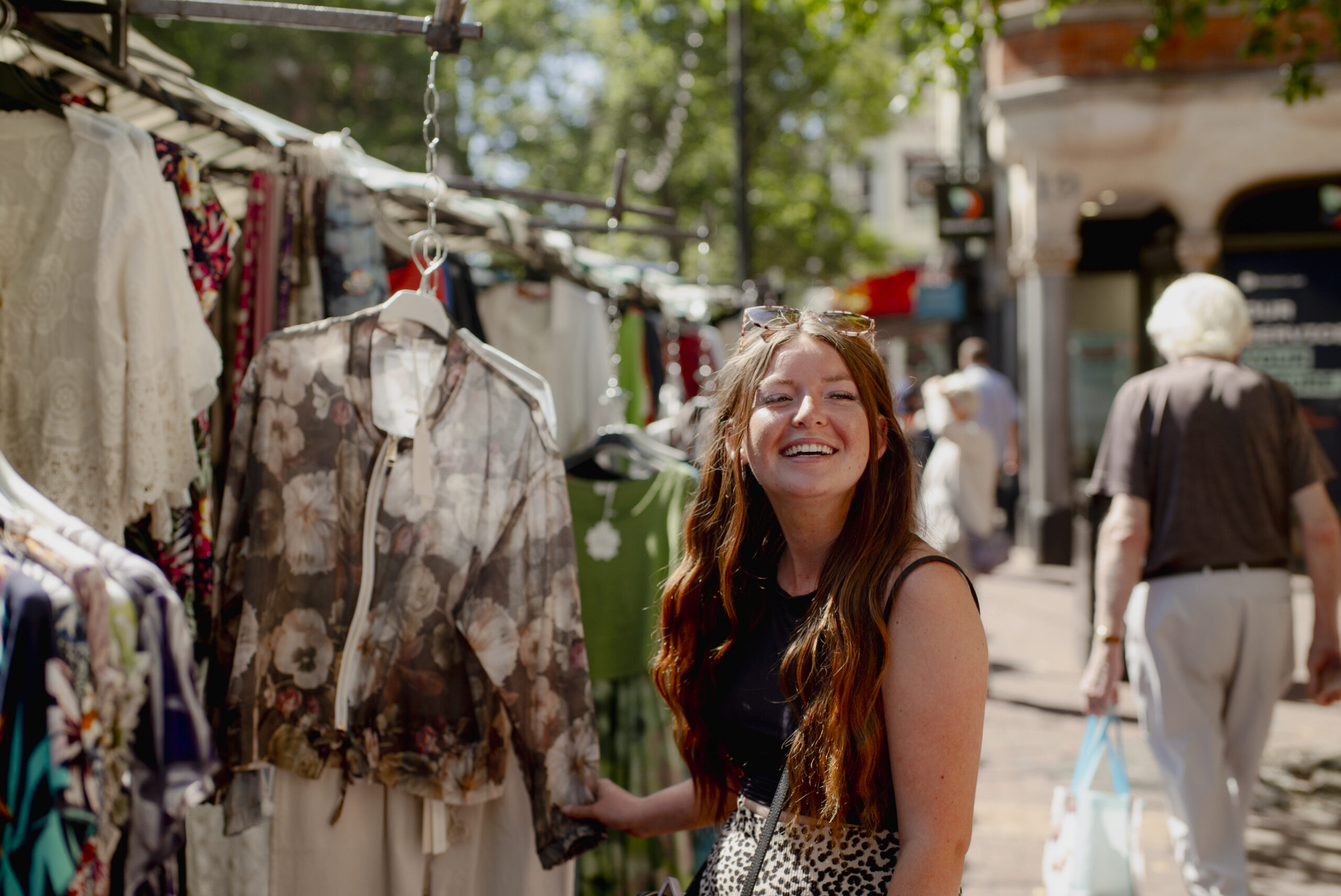 A women enjoying the clothes stall at Rugby Market.