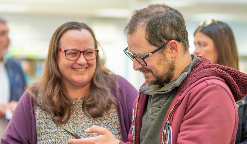 Two people talking to each other and smiling